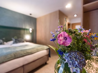 Details in den Zimmern, Blumenstrauß im Hintergrund ist ein Doppelbett
