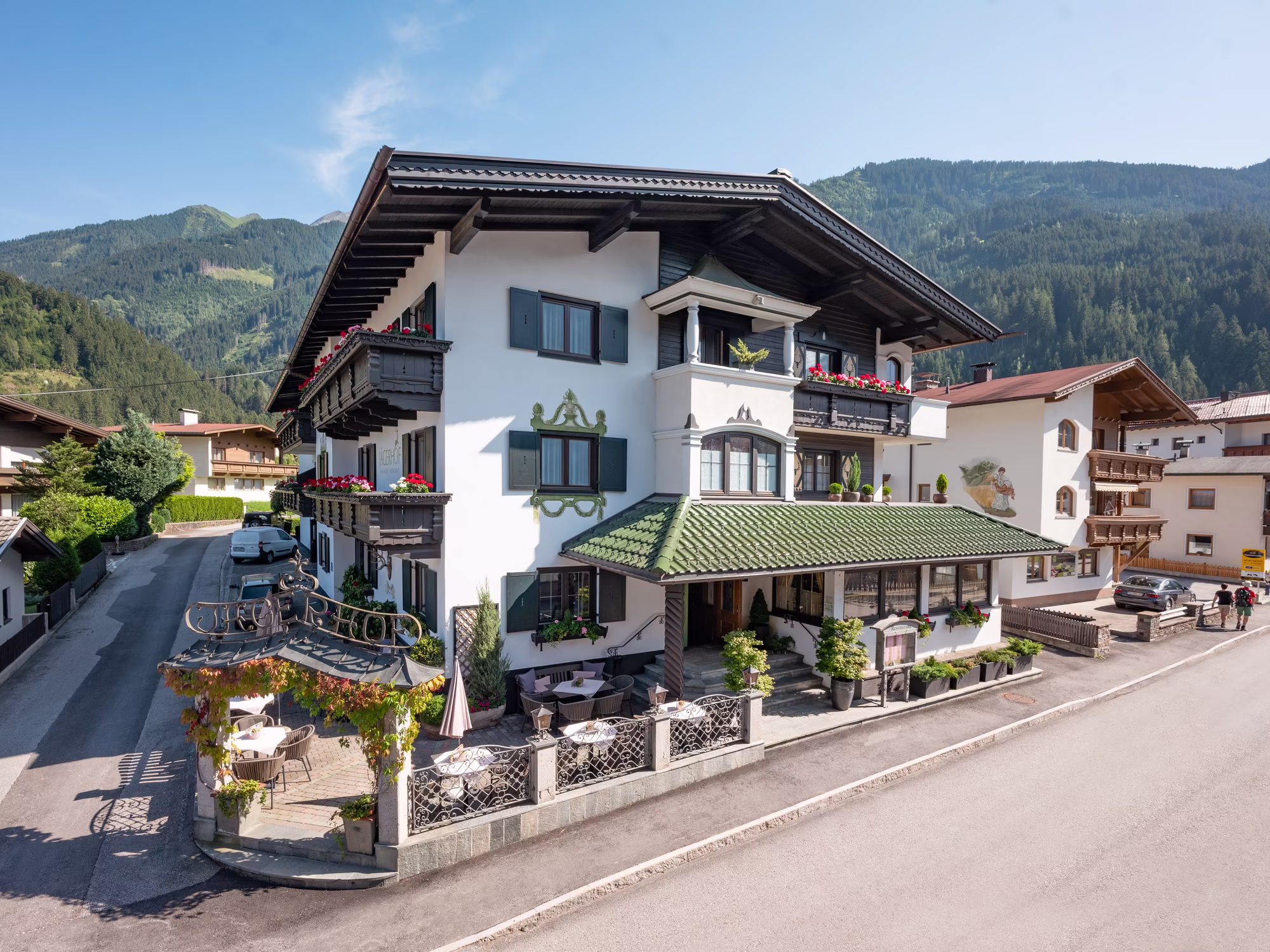 Aussenansicht vom Hotel Jägerhof, grün bewachsender Torbogen und direkt an der Tuxerstraße